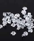 M6 Four Prong Tee Nuts for Woodworking, Heavy Duty Zinc Plated Carbon Steel Captive Nuts scattered on black background