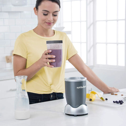 Person holding 24 Ounce Tall Cup With Standard Lip Ring For Personal Blenders On The Go, BPA Free Tritan, Clear With Gray Lip Ring
