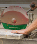 Diamond wet core drill bit with saw blade; side view cutting concrete on a green base.