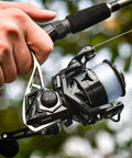 Hand holding Megatron Spinning Fishing Reel Size 5000 for freshwater and saltwater use, showcasing durable aluminum build and design.