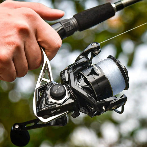 Hand holding Megatron Spinning Fishing Reel Size 5000 for freshwater and saltwater use, showcasing durable aluminum build and design.