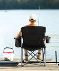 Man fishing on dock with Oversized Camping Folding Chair With Quad Lumbar Back Support, cup holder, and cooler bag