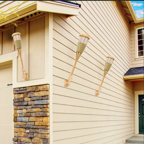 Upgraded Flickering Flame Solar Powered Torches to Light Up Outdoor Gardens and Patios on house wall in bamboo weave design