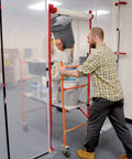 Workers using Heavy Duty Dust Barrier Zipper 2 Pack Self Adhesive Entry Door For Remodeling Jobs Red HDAZ2 in a construction area
