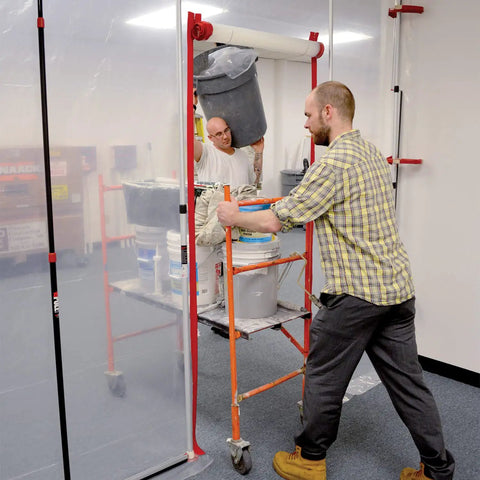 Workers using Heavy Duty Dust Barrier Zipper 2 Pack Self Adhesive Entry Door For Remodeling Jobs Red HDAZ2 in a construction area