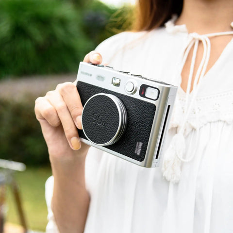 Person holding camera with Leather Lens Cap For Insta Mini Evo Camera, Aluminum Anti Dust Anti Scratches Lightweight Lens Cover.