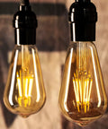 Two Six Pack Vintage Style LED Edison Light Bulbs, 6W Realistic Filament, 60W Equivalent, hanging with warm glow, black finish.