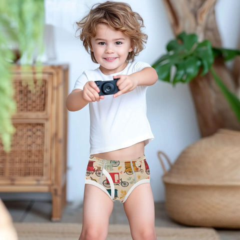 Fresh Duds Cotton Boys Briefs Featuring Classic Rickshaw Mobile Graphics For Active Toddler Guys worn by a smiling boy with a camera.