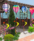Four Pack Colorful Hot Air Balloon Wind Spinners For Yard Decor With Curly Tails That Spin In The Wind hung in garden