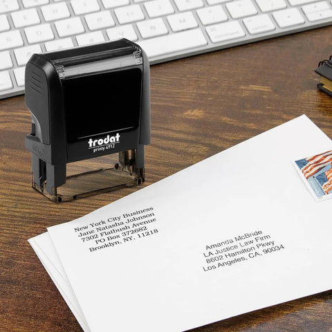 Custom Self Inking Signature Stamp Personalized With Your Favorite Fonts And Rich Ink Colors Serves Up Hassle Free Branding For Work Or Play Designed As A Top Shelf Game Changer on a wooden desk with envelopes.