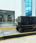 Heavy Duty Self Propelled Machinery Moving Dolly with Remote Control transporting large industrial box on a ramp.