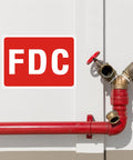Rock Solid 2 Pack FDC Sign For Fire Department Connection Made From Premium Aluminum Outdoor Plaque on wall near red pipes.