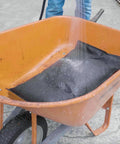 Water poured on Water Activated Flood Bag 12x24 Inches in wheelbarrow, expanding for flood control, sand-free use