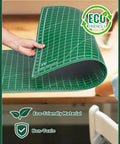 Person bending Self Healing Cutting Mat 23 By 35 Inches Large Double-Sided Rotary Cutting Mat For Sewing, Quilting, Scrapbooking, Fabric And Craft Projects With Clear Grid Lines, Angles And Guides, Green A1 with eco-friendly label.