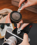 Person using KR03 EDC Pry Bar Multitool With Flathead And Phillips Driver, Bottle Opener, Three Hex Wrenches on camera lens.