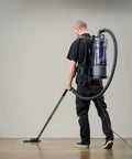 Man using Powerhouse Lightweight Bagless Backpack Vacuum With Killer Suction on hard floor, demonstrating efficient cleaning.