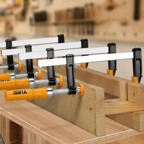 Four Pack 6-Inch Bar Clamps For Woodworking Heavy-Duty Steel F-Clamps With 300 Lb Load And Ergonomic Handles Ideal For Glue-Ups DIY Projects Home Renovations Garage Or Workshop Woodworking clamping wood boards in a workshop