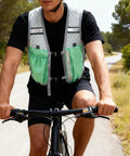 Cyclist wearing Dope Ultralight Running Hydration Vest with 16.9 oz soft flasks, reflective gear, adjustable straps, outdoor path