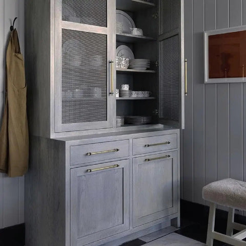 Top Tier Light Oak Reactive Water Based Wood Stain Zero VOC Heavy Duty 55 Gallon Drum near a Nordic-style cabinet with dishes.