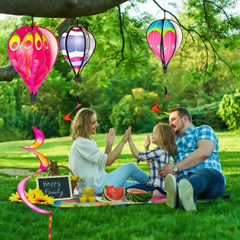 Family picnic under Four Pack Colorful Hot Air Balloon Wind Spinners For Yard Decor With Curly Tails That Spin In The Wind
