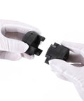 L-jaw coupling connectors, close-up view: two black plastic pieces (1-1/8 in to 1-1/8 in), held by gloved hands.