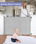 Retractable Baby Gate For Stairs And Doorways, 33 Inch Tall, Expands To 55 Inch Wide, shown with baby and mother in living room
