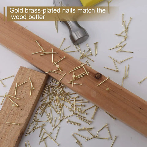 900 Piece Brass Plated Finishing Nails 3 4 Inch By 17 Gauge Flat Head Carbon Steel Fasteners scattered on wood surface.