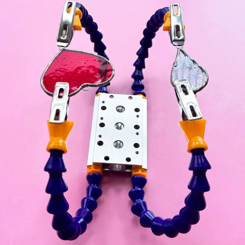 Soldering Clamp For Stained Glass And Jewelry Making, four adjustable arms with stained glass pieces, pink background