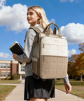 Rolling puffer backpack for women with wheels, two-tone beige and taupe quilted exterior, luggage-style laptop bag.