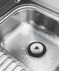 Rubber Bathtub Drain Plug with Stainless Steel Easy Pull-Out Stopper in a wet stainless steel sink.