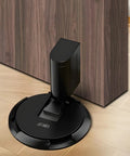 No Magnetic Door Stopper With Mechanical Lock, Adjustable Indoor Door Holder, installed on wood floor and brown door, Matte Black.