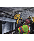 Worker using Onboard Dust Extractor for 1-1/8-Inch SDS Plus Rotary Hammers in a tight space on a ceiling.