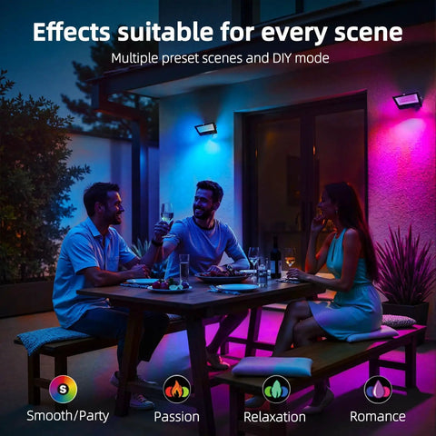 Outdoor 50W RGBW LED Flood Light with remote control illuminating a patio with colorful light effects during evening dining.