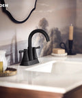 Ronan Matte Black Two-Handle 4-Inch Centerset Modern Bathroom Faucet With Push-Down Drain installed on white vanity