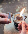 Hands using Relightable Permanent Fire Starter Metal Kit 2 Pack, Waterproof Keychain Lighter Striker for stoves and outdoors.