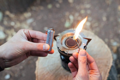 Hands using Relightable Permanent Fire Starter Metal Kit 2 Pack, Waterproof Keychain Lighter Striker for stoves and outdoors.