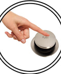 Hand pressing tip-toe push-to-close drain plug of One And A Half Inch Bath Waste And Overflow Kit, Satin Nickel Finish.