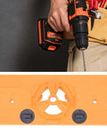 35mm hinge hole jig drill base in orange with circular center guide and two dial knobs; cordless drill with bit in use