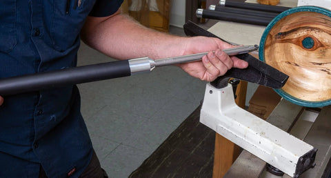 Three-piece carbide woodturning tool set with foam-grip handle mounted on lathe, side view