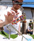Person performing trick with Finger Skate Park Kit Bigger Ramp Set With Five Parts For Fingerboard Training and graffiti deck.