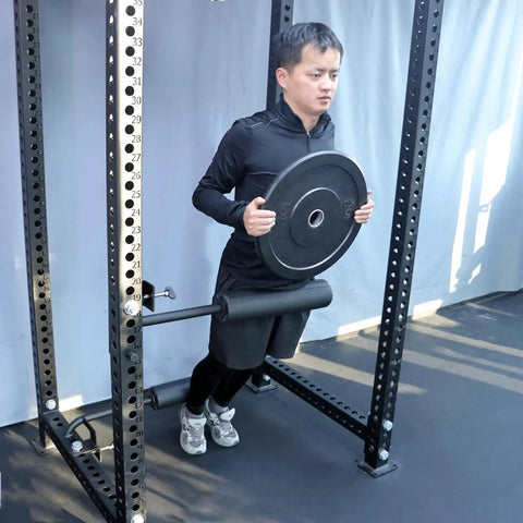 Person using Single Leg Squat Roller Attachment for Power Rack and Home Gym with weight plate, enhances quads glutes hamstrings.