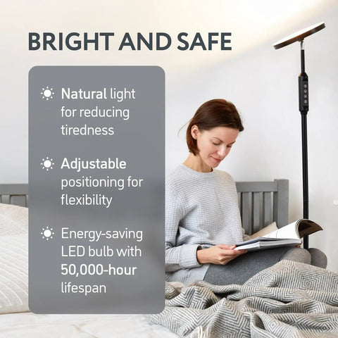 Lit 24W LED Daylight Floor Lamp Free Standing Uplight Torchiere in a bedroom with a woman reading on bed