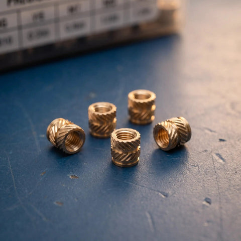 Premium 48Pcs Brass M4 Heat Set Threaded Inserts For 3D Printing With Knurled Design on blue surface, showcasing five inserts.