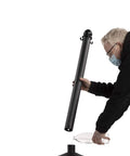 Person assembling Yellow Plastic Stanchion Set With 2.5 Inch Diameter Posts, 40 Inch High, 50 Foot Chain, Six Pack Crowd Control Barriers.