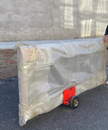 Person using Top Shelf Heavy Duty Panel Dolly And Portable Drywall Sheet Cart With Adjustable Clamps for easy hauling of wrapped panel.
