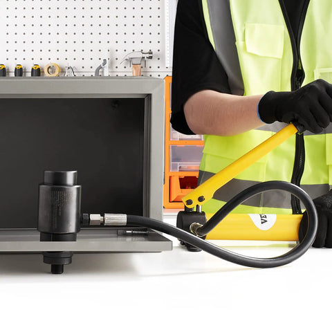 Worker using 15 Ton Hydraulic Knockout Punch Kit With 10 Punches And Dies, tools laid out, close-up on handle and hydraulic system