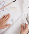 Frisket Masking Film Matte 10 Inch By 4 Yard for artists used over pencil drawing with grid lines, showing hands applying film