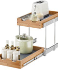 The Real Deal Heavy Duty Two Tier Pull Out Cabinet Organizer With Super Smooth Gliding Wood Shelves, 14x21 inches, holding a toaster and pots.