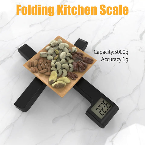 Folding Kitchen Scale 5000g/1g, Space Saving X Fold Design, LCD Display, Tare Function. Black scale with nuts on top.
