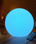 Huge 16 Inch RGB Night Light Ball With Remote Control Color Changing Waterproof Glow For Nursery Home Decor Living Room And Study Area Ideal Kids Night Light Battery Rechargeable Dimmable Lamp glowing blue on table with remote nearby